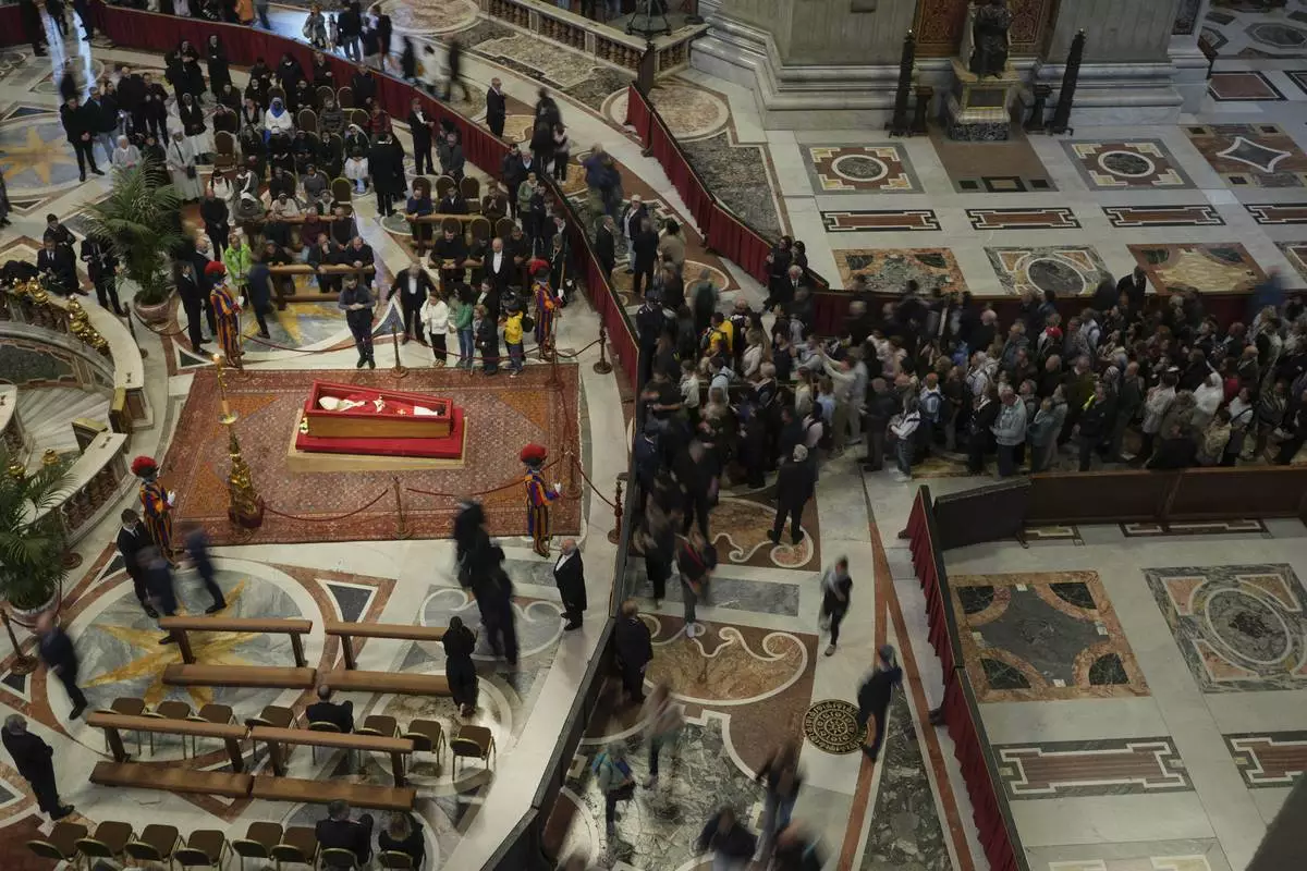 Faithful pay their respects to Pope Francis lying in state inside St. Peter's Basilica at the Vatican, Thursday, April 24, 2025. (AP Photo/Alessandra Tarantino)