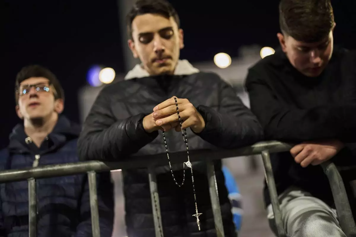 Men attend a rosary prayer for the late Pope Francis, at St. Mary Major Basilica in Rome, Wednesday, April 23, 2025. (AP Photo/Bernat Armangue)