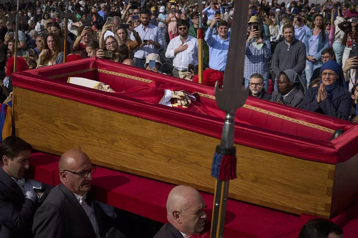 The body of Pope Francis is carried into St. Peter's Basilica at the Vatican, Wednesday, April 23, 2025, where he will lie in state for three days. (AP Photo/Emilio Morenatti)