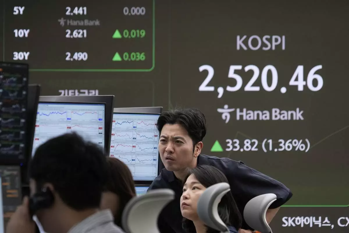Currency traders watch monitors near a screen showing the Korea Composite Stock Price Index (KOSPI) at the foreign exchange dealing room of the KEB Hana Bank headquarters in Seoul, South Korea, Wednesday, April 23, 2025. (AP Photo/Ahn Young-joon)