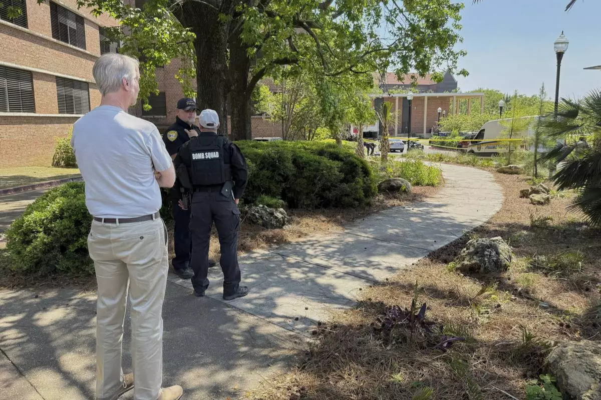 Dozens of patrol vehicles, including a forensics van, are stationed outside of Florida State University’s student union building, the scene of a shooting, Thursday, April 17, 2025, in Tallahassee, Fla. (AP Photo/Kate Payne)