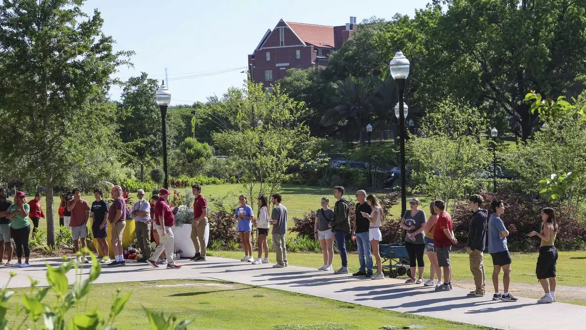 Students wait to retrieve their personal items from the Florida State Student Union building, Tallahassee, Fla., Friday, April 18, 2025. (AP Photo/Gary McCullough)