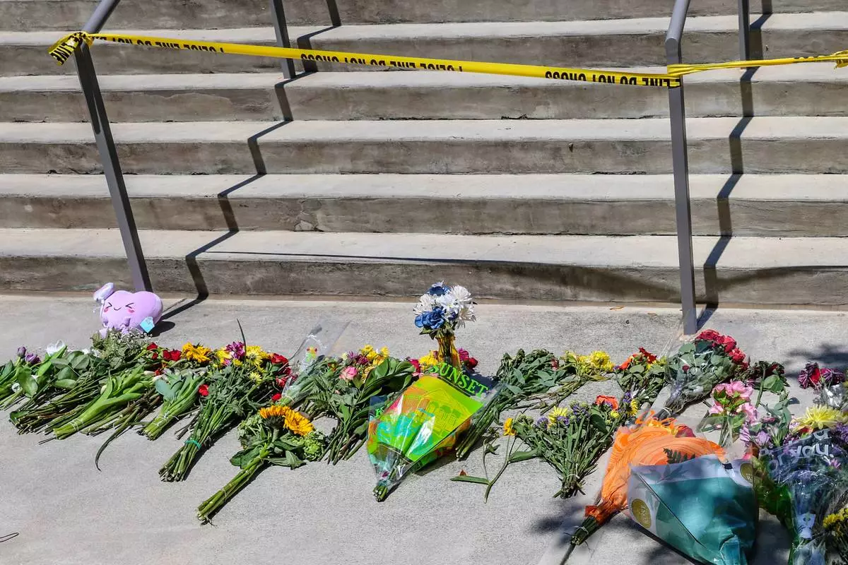 Flowers placed by students sit near police tape near the Florida State Student Union building, Tallahassee, Fla., Friday, April 18, 2025. (AP Photo/Gary McCullough)