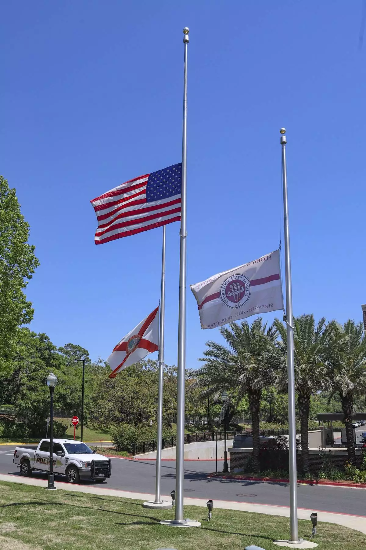Flags flown at half-staff near the Florida State Student Union building, Tallahassee, Fla., Friday, April 18, 2025. (AP Photo/Gary McCullough)