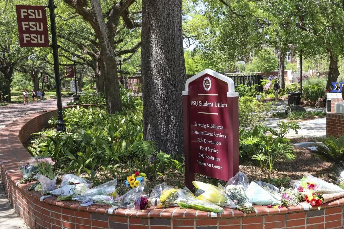Flowers placed by students sit next to a sign for the Florida State Student Union building, Tallahassee, Fla., Friday, April 18, 2025. (AP Photo/Gary McCullough)