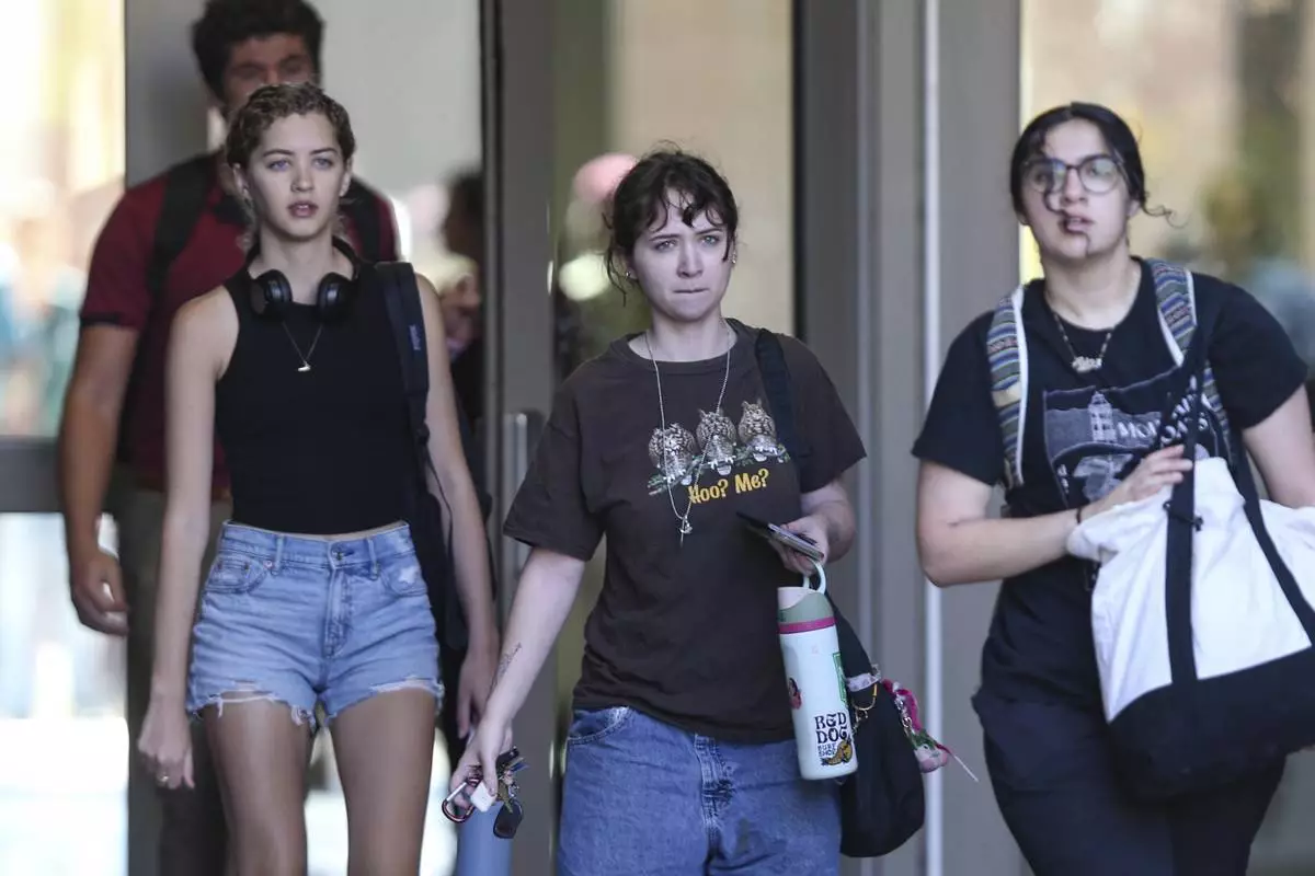 Students leave after retrieving their personal items from the Florida State Student Union, Tallahassee, Fla., Friday, April 18, 2025. (AP Photo/Gary McCullough)