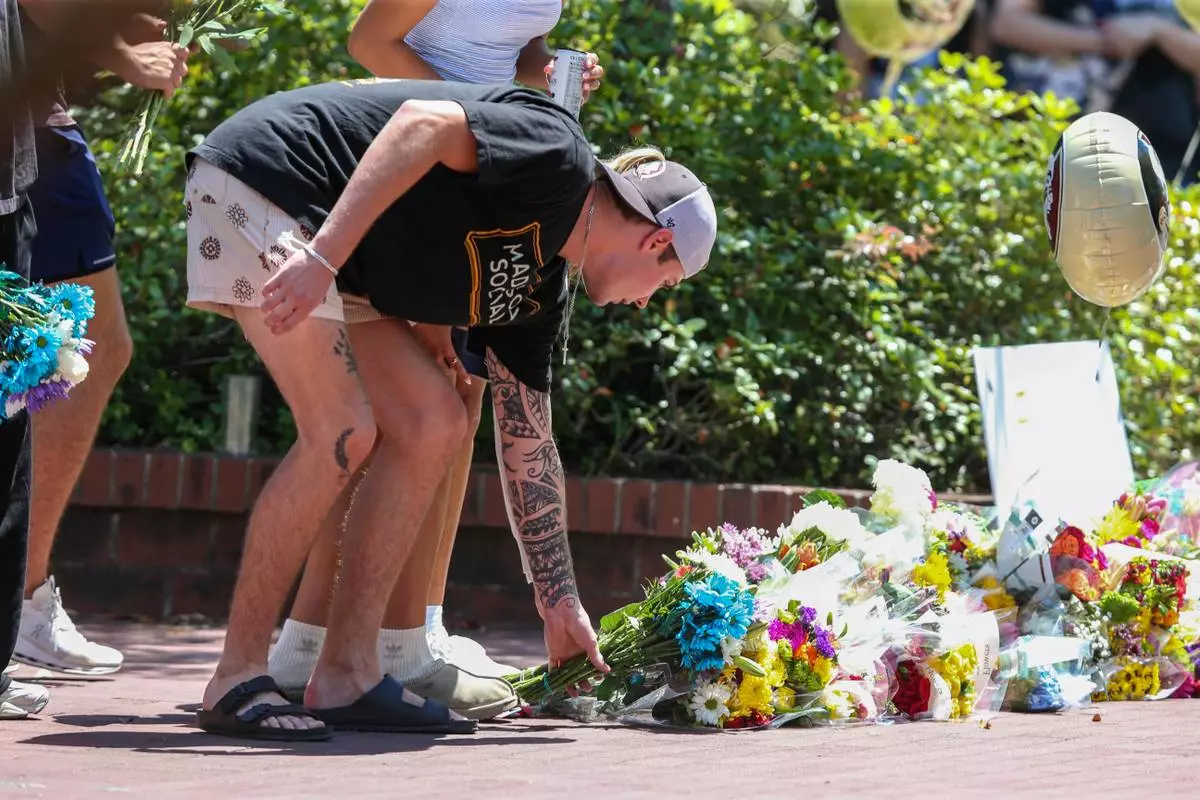 A student places flowers near the Florida State Student Union building, Tallahassee, Fla., Friday, April 18, 2025. (AP Photo/Gary McCullough)