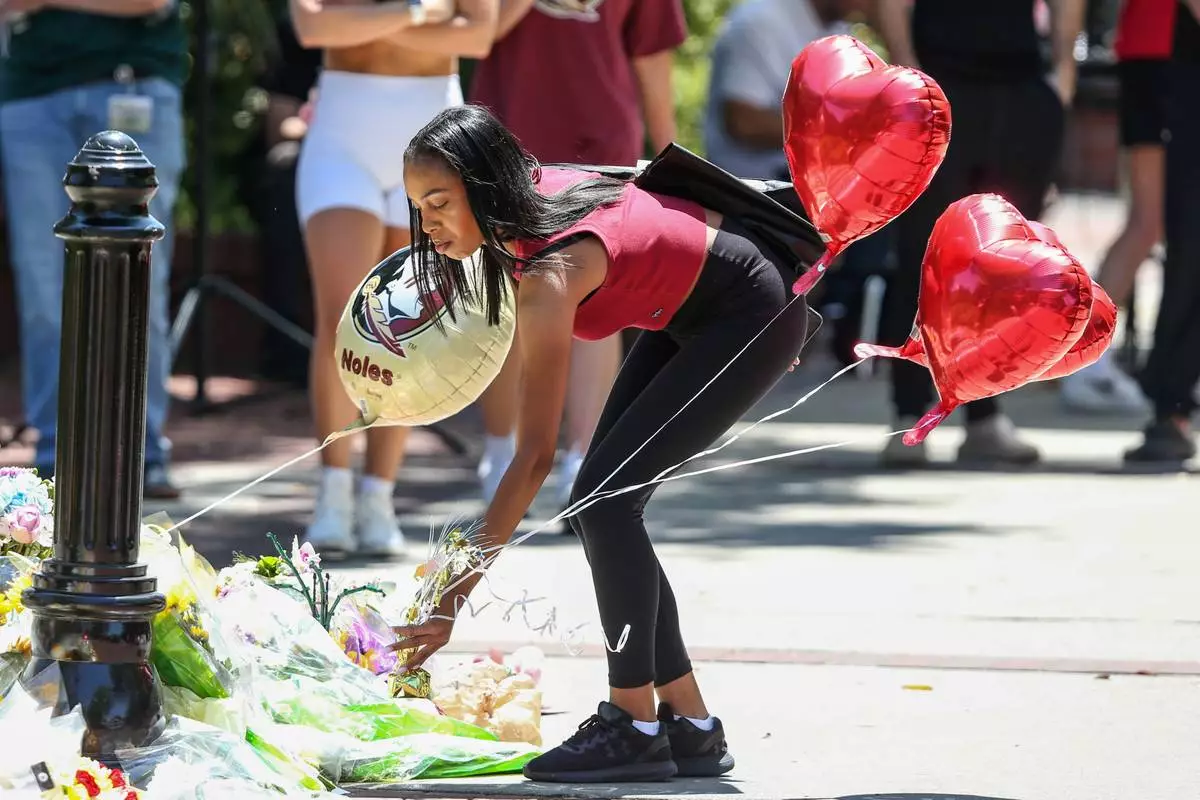 A student places heart-shaped balloons near the Florida State Student Union building, Tallahassee, Fla., Friday, April 18, 2025. (AP Photo/Gary McCullough)