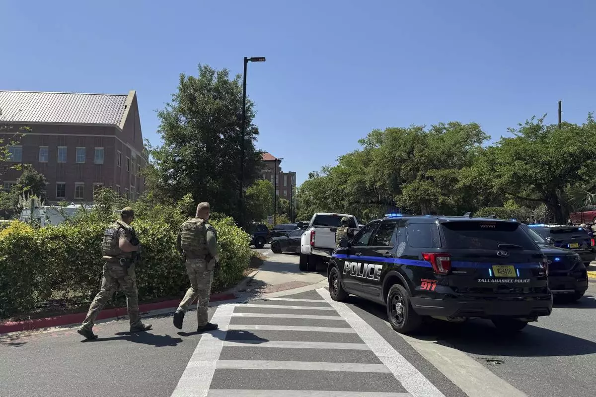 Dozens of patrol vehicles, including a forensics van, are stationed outside of Florida State University’s student union building, the scene of a shooting, Thursday, April 17, 2025, in Tallahassee, Fla. (AP Photo/Kate Payne)