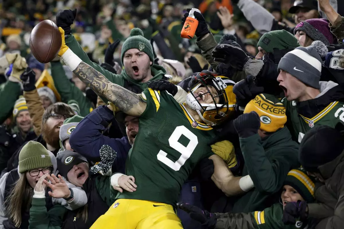 FILE - Green Bay Packers wide receiver Christian Watson (9) celebrates with fans after scoring a touchdown during the second half of an NFL football game against the Dallas Cowboys, Sunday, Nov. 13, 2022, in Green Bay, Wis. AP Photo/Matt Ludtke, File)