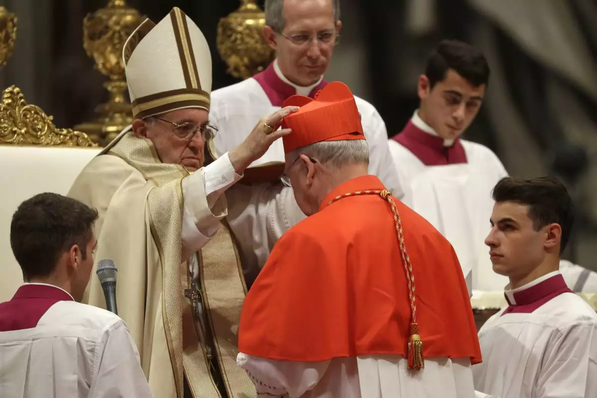 FILE - New Cardinal Kevin Joseph Farrell, prefect of the Vatican dicastery for laity, family and life, receives the red three-cornered biretta hat from Pope Francis inside St. Peter's Basilica at the Vatican on Nov. 19, 2016. (AP Photo/Gregorio Borgia, File)