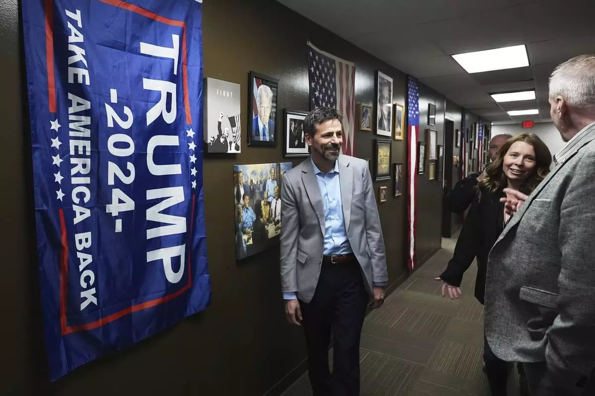 Ryan Kelley, left, arrives before his talk at the Jackson County Republican headquarters, Thursday, April 10, 2025, in Jackson, Mich. (AP Photo/Paul Sancya)