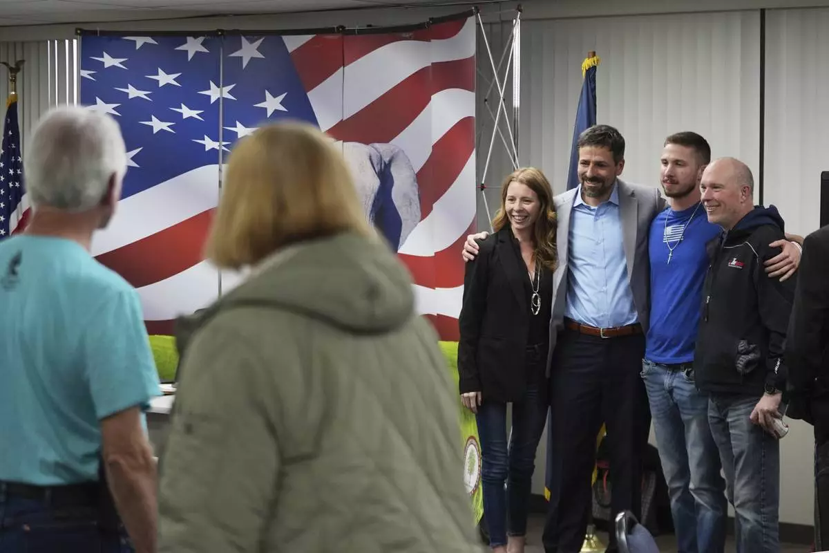 Ryan Kelley, third from right, poses for photos after his talk at the Jackson County Republican headquarters, Thursday, April 10, 2025, in Jackson, Mich. (AP Photo/Paul Sancya)