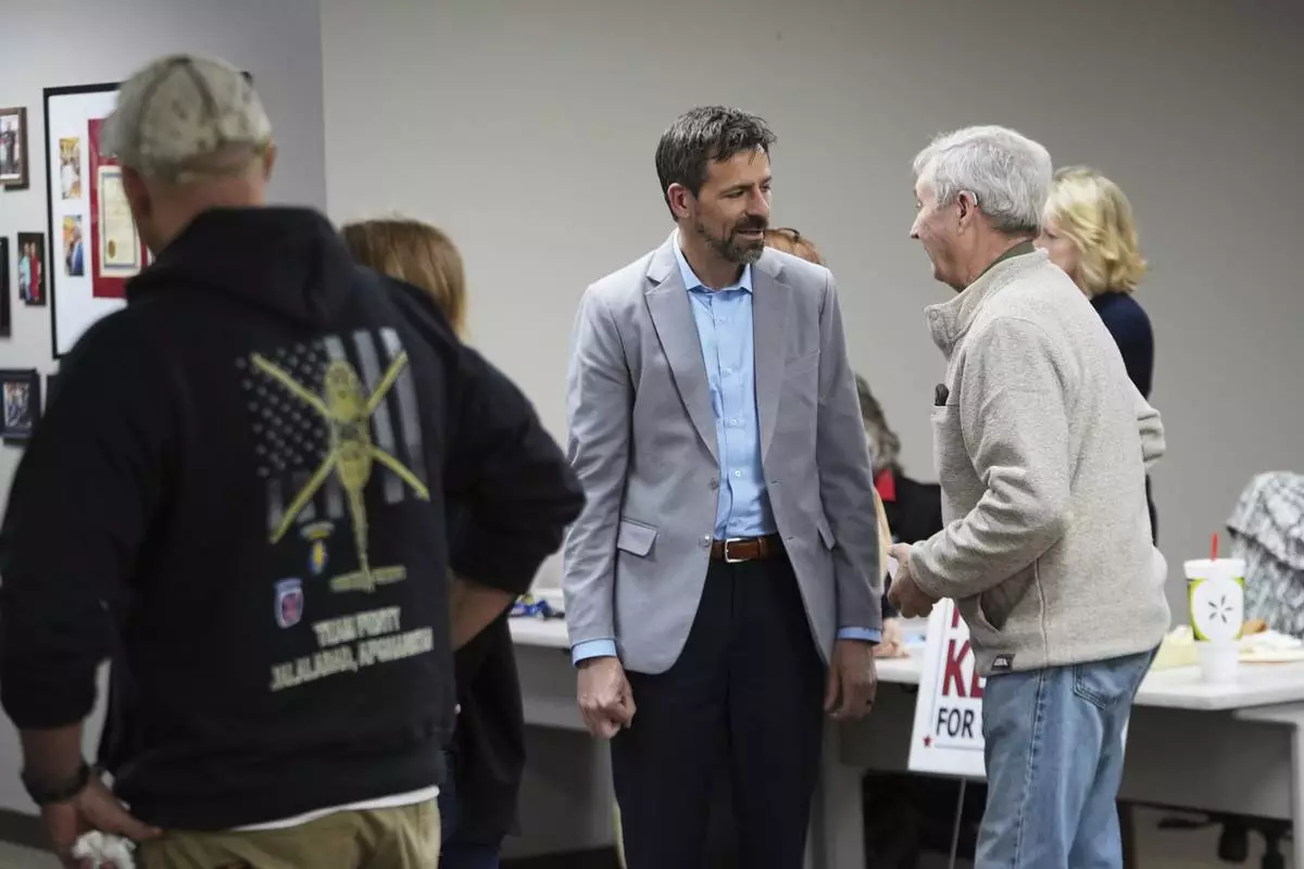 Ryan Kelley, left, talks with William "Hank" Choate before speaking at the Jackson County Republican headquarters Thursday, April 10, 2025, in Jackson, Mich. (AP Photo/Paul Sancya)