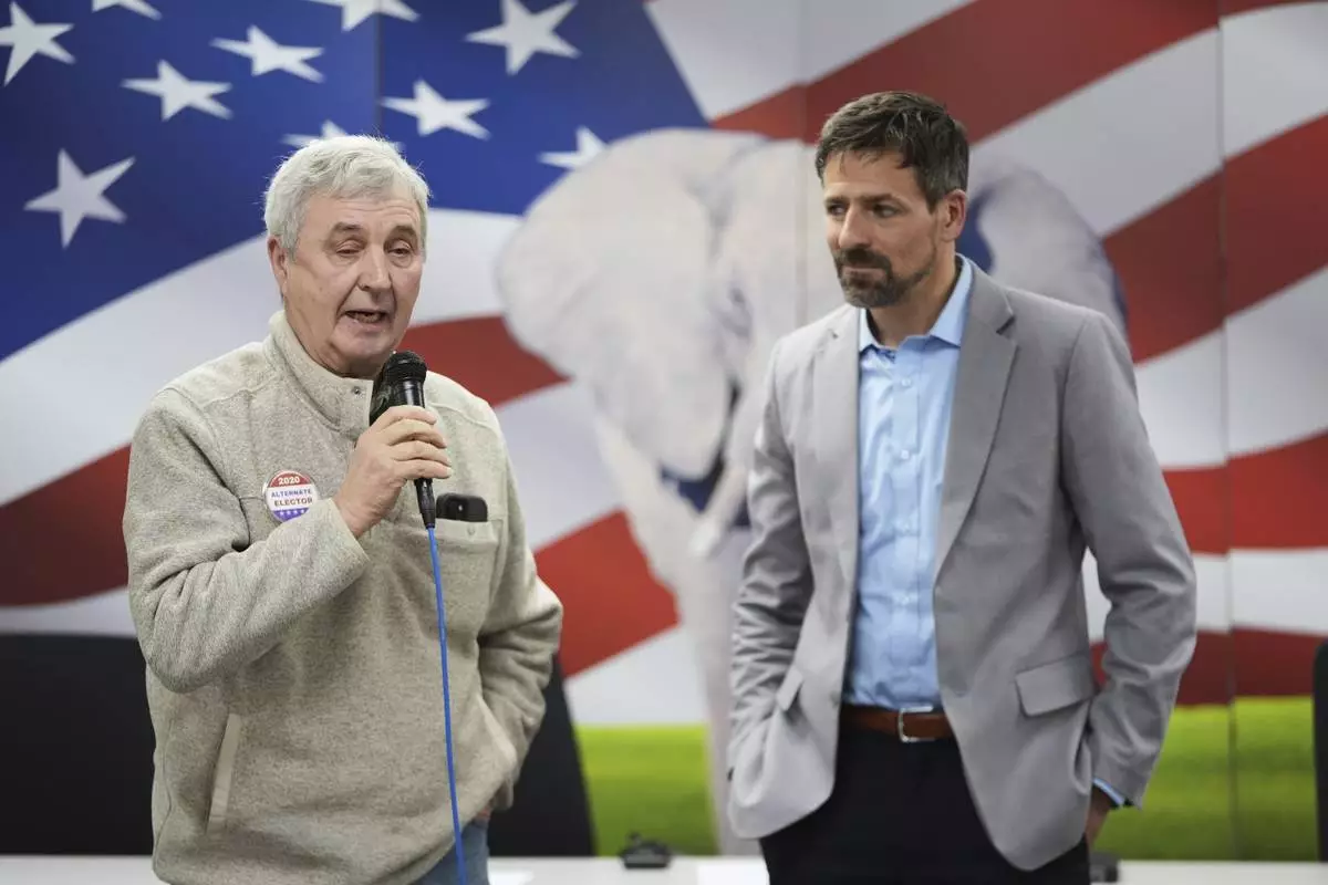 Ryan Kelley, right, listens to William "Hank" Choate speak at the Jackson County Republican headquarters, Thursday, April 10, 2025, in Jackson, Mich. (AP Photo/Paul Sancya)