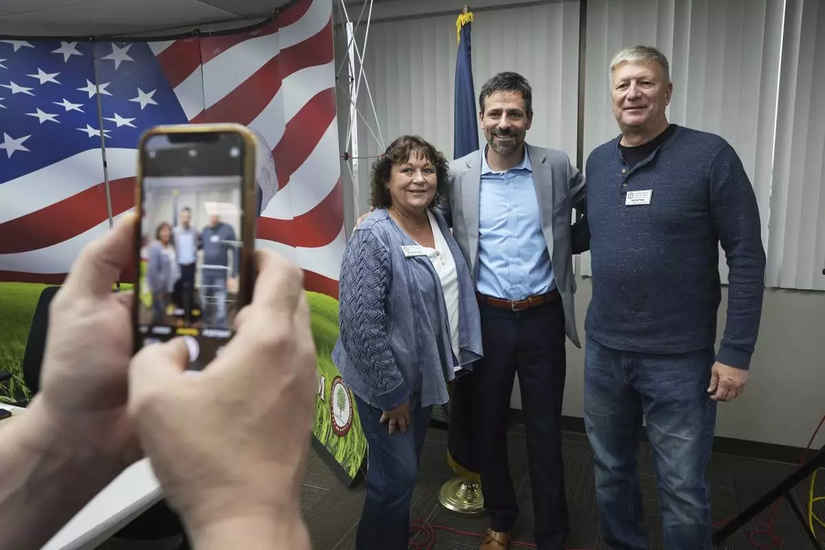Ryan Kelley, center, poses for a photo after his talk at the Jackson County Republican headquarters, Thursday, April 10, 2025, in Jackson, Mich. (AP Photo/Paul Sancya)