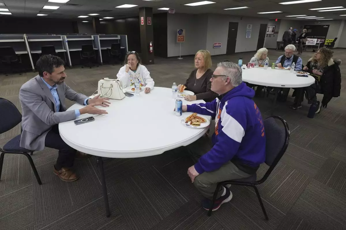 Ryan Kelley, left, talks with attendees before speaking at the Jackson County Republican headquarters, Thursday, April 10, 2025, in Jackson, Mich. (AP Photo/Paul Sancya)
