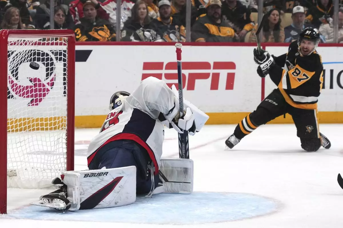 Pittsburgh Penguins' Sidney Crosby (87) get a shot past Washington Capitals goaltender Clay Stevenson, left, for a goal during the second period of an NHL hockey game in Pittsburgh, Thursday, April 17, 2025. (AP Photo/Gene J. Puskar)