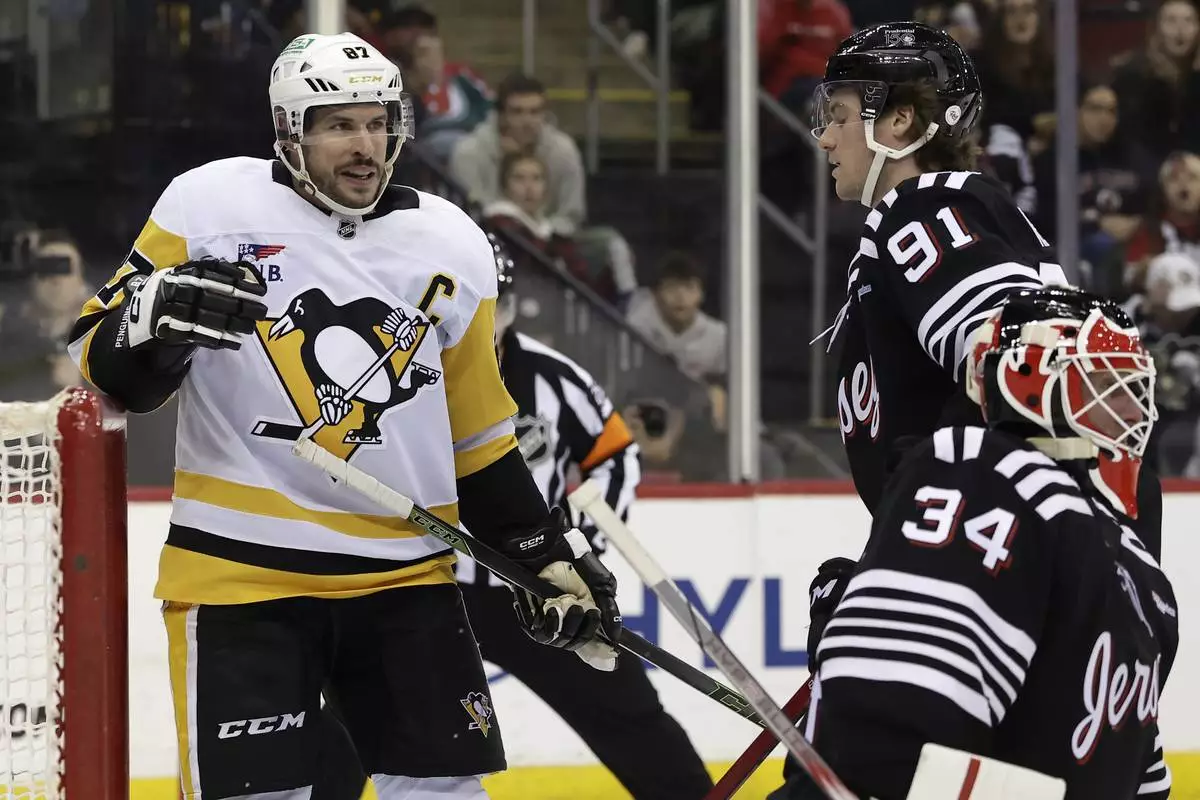 Pittsburgh Penguins center Sidney Crosby (87) reacts after scoring a goal past New Jersey Devils goaltender Jake Allen in the third period of an NHL hockey game Friday, April 11, 2025, in Newark, N.J. (AP Photo/Adam Hunger)