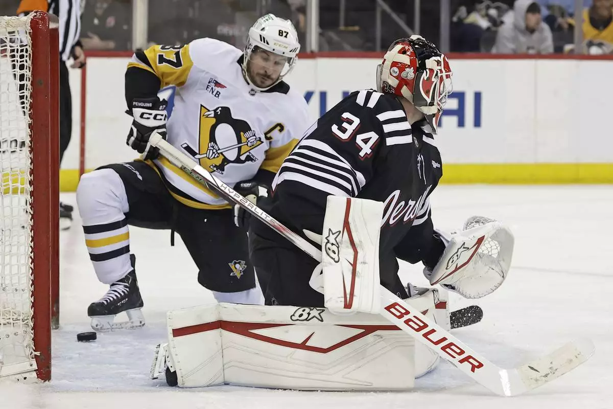Pittsburgh Penguins center Sidney Crosby (87) scores a goal past New Jersey Devils goaltender Jake Allen in the third period of an NHL hockey game Friday, April 11, 2025, in Newark, N.J. (AP Photo/Adam Hunger)