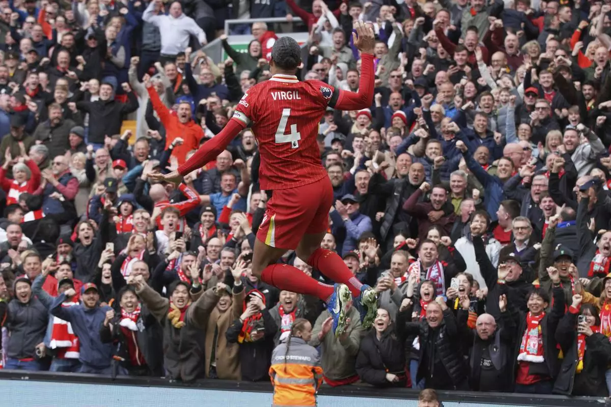 Liverpool's Virgil van Dijk celebrates after scoring his side's second goal during the English Premier League soccer match between Liverpool and West Ham United at Anfield in Liverpool, Sunday, April 13, 2025. (AP Photo/Ian Hodgson)