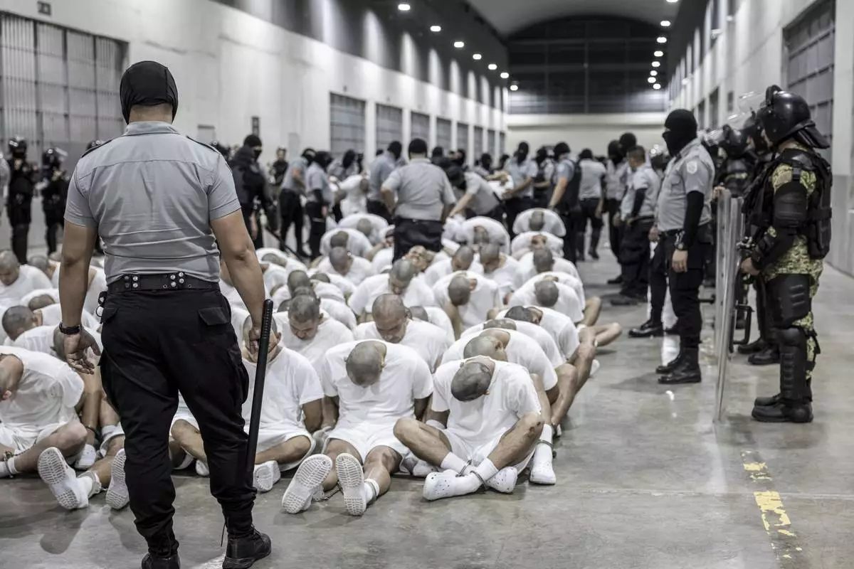 FILE - In this photo provided by El Salvador's presidential press office, a prison guard transfers deportees from the U.S., alleged to be Venezuelan gang members, to the Terrorism Confinement Center in Tecoluca, El Salvador, March 16, 2025. (El Salvador presidential press office via AP, File)