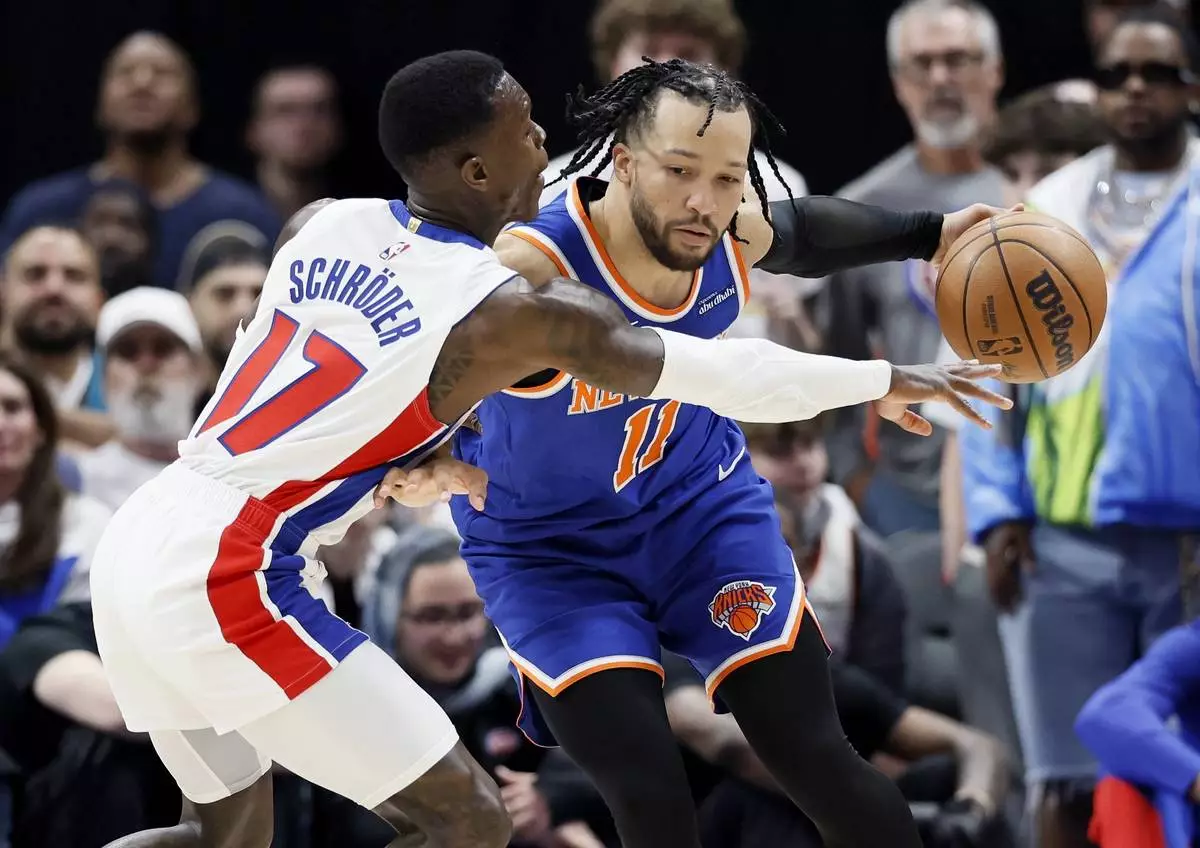 Detroit Pistons guard Dennis Schroder (17) tried to steal the ball from New York Knicks guard Jalen Brunson (11) during the second half of Game 3 of an NBA basketball first-round playoff series Thursday, April 24, 2025, in Detroit. (AP Photo/Duane Burleson)
