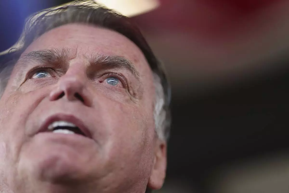 FILE - Brazil's former President Jair Bolsonaro speaks to the media as he arrives at the Brasilia International Airport in Brasilia, Brazil, March 25, 2025. (AP Photo/Luis Nova, File)