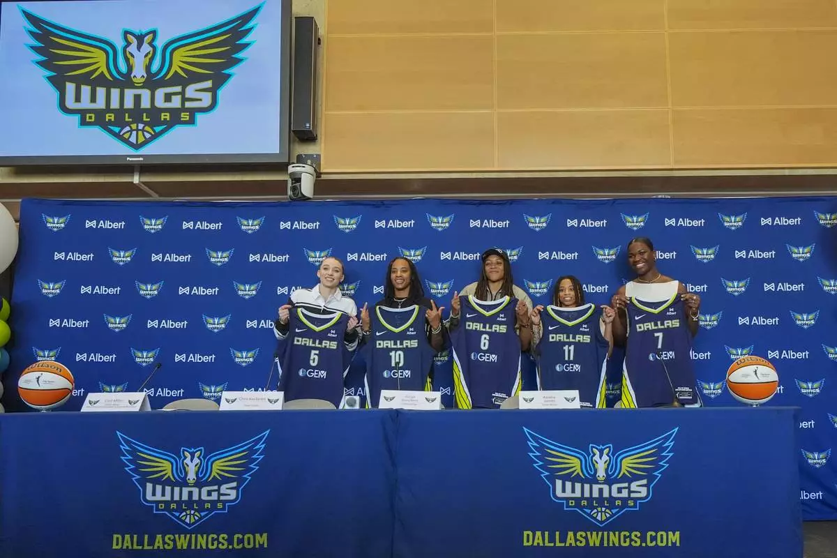Dallas Wings' WNBA basketball draft selections, from left, Paige Bueckers, Aziaha James, Madison Scott, JJ Quinerly and Aaronette Vonleh pose for photographs during an introductory press conference Wednesday, April 23, 2025, in Dallas. (AP Photo/Julio Cortez)