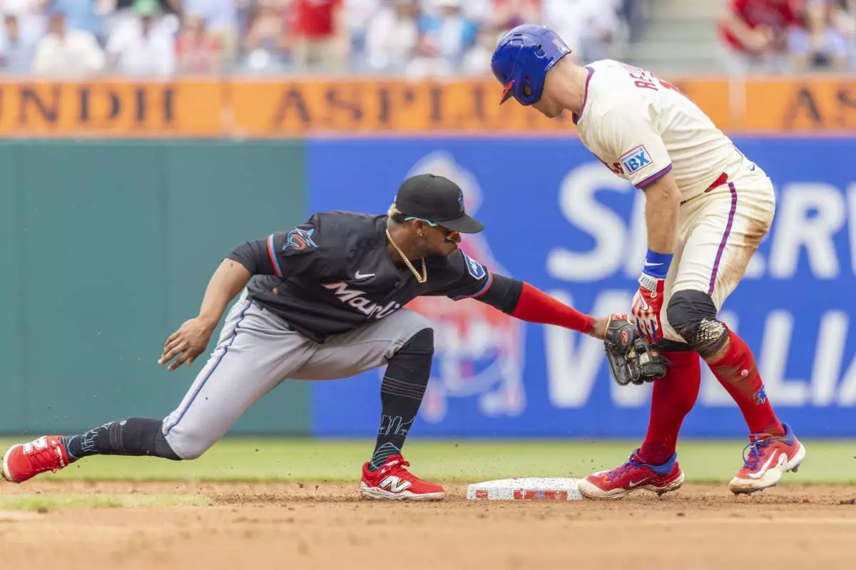 Philadelphia Phillies' J.T. Realmuto is safe at second on a double before Miami Marlins second baseman Otto Lopez can make the tag in the second inning of a baseball game, Saturday, April 19, 2025, in Philadelphia. (AP Photo/Laurence Kesterson)