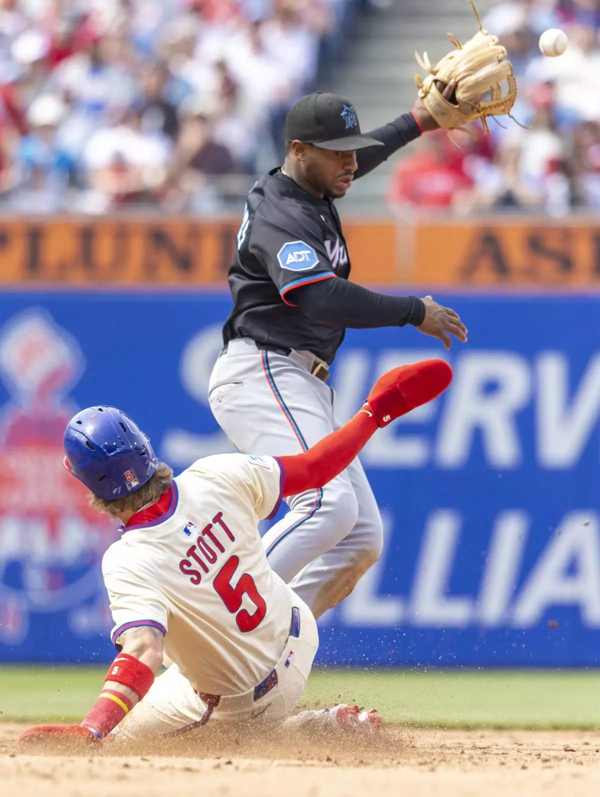 Philadelphia Phillies' Bryson Stott (5) is safe at second before Miami Marlins shortstop Xavier Edwards can make the catch in the fifth inning of a baseball game, Saturday, April 19, 2025, in Philadelphia. (AP Photo/Laurence Kesterson)