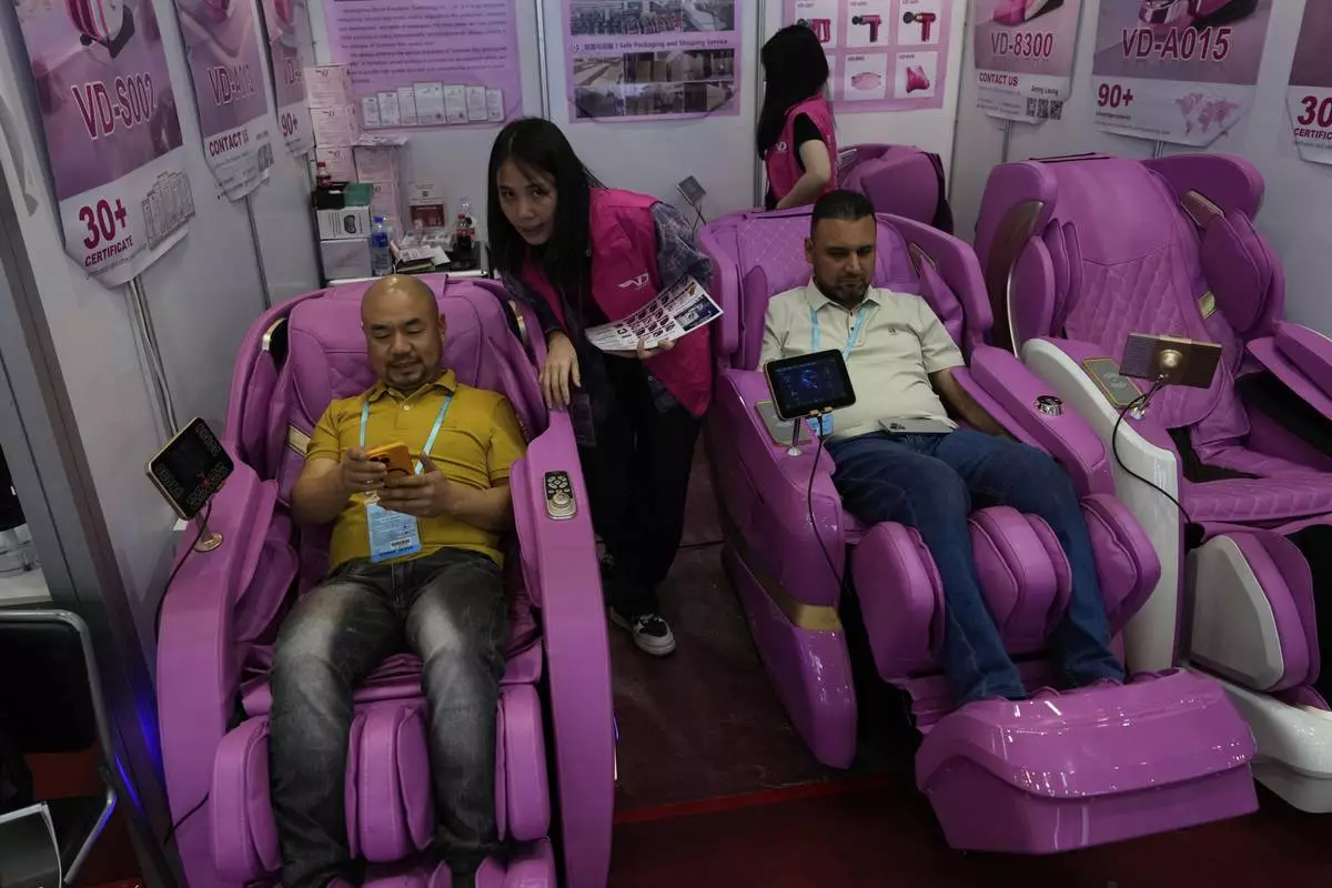 Visitors try out massage chairs at the 137th Canton Fair in Guangzhou in southern China's Guangdong province, Tuesday, April 15, 2025. (AP Photo/Ng Han Guan)