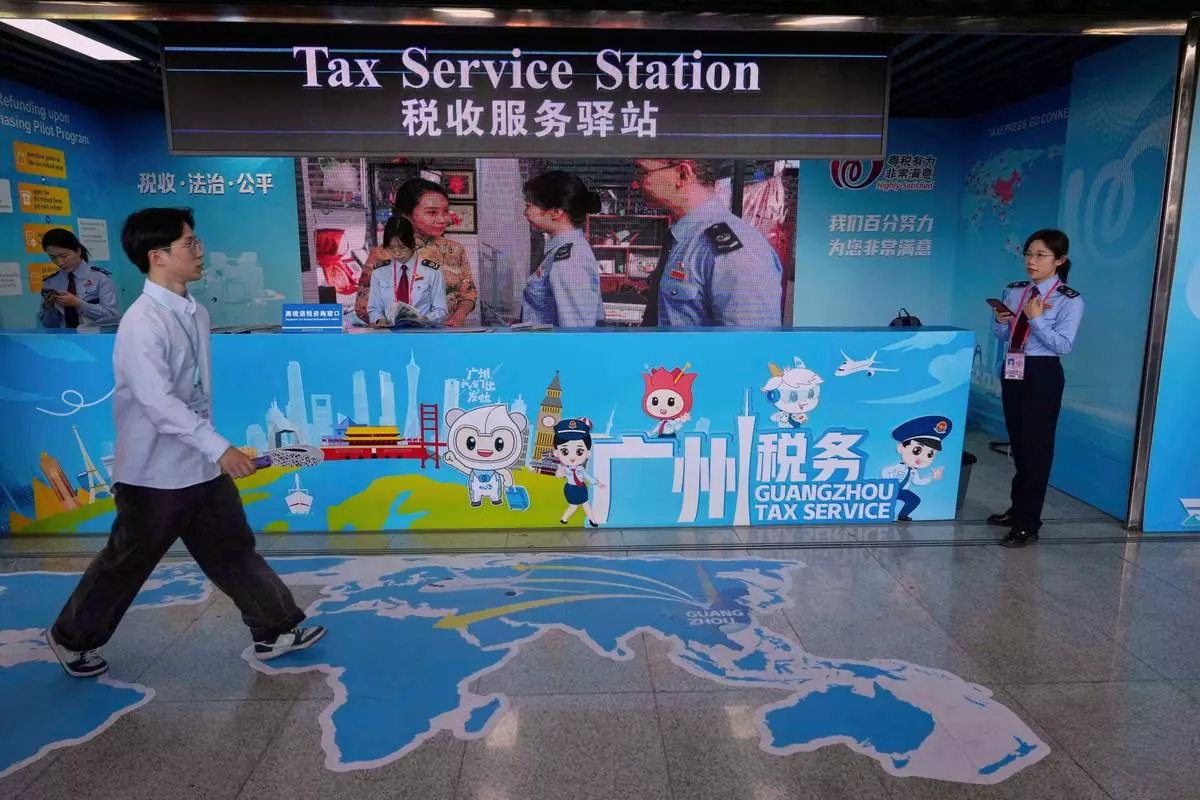 A man walks by the Guangzhou Tax Service booth at the 137th Canton Fair in Guangzhou in southern China's Guangdong province on Tuesday, April 15, 2025. (AP Photo/Ng Han Guan)