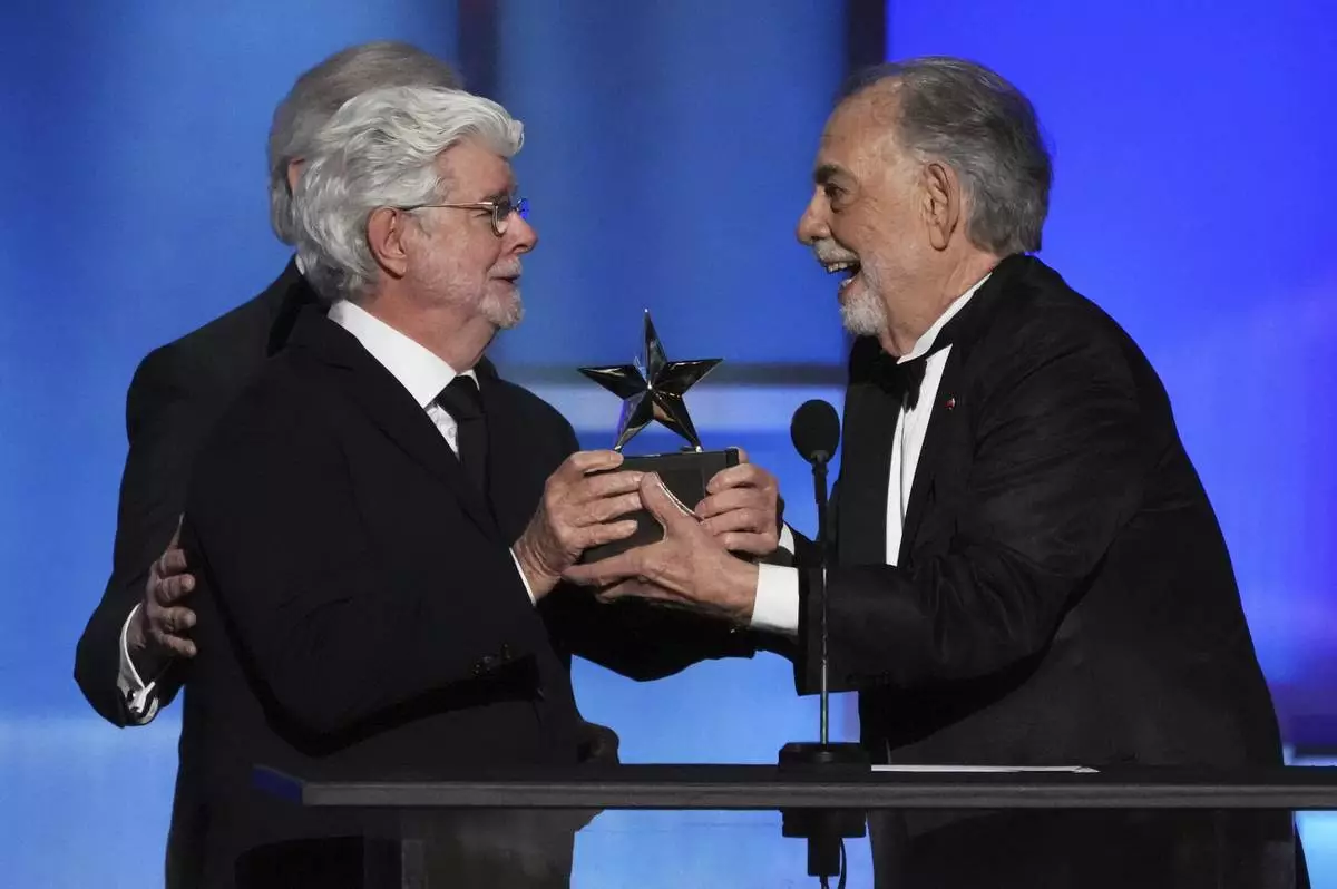 Filmmaker Francis Ford Coppola, right, accepts the 50th AFI Life Achievement Award from presenter George Lucas during a gala tribute to Coppola on Saturday, April 26, 2025, at the Dolby Theatre in Los Angeles. (AP Photo/Chris Pizzello)