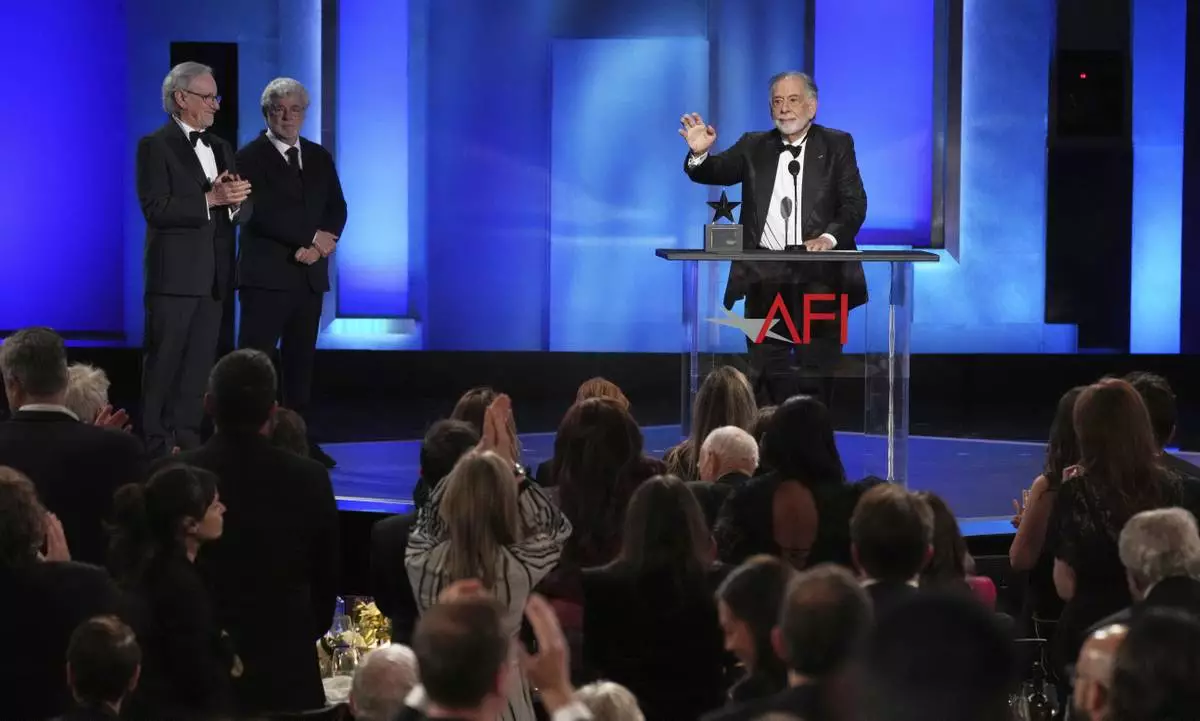 Filmmaker Francis Ford Coppola, right, gets a standing ovation as presenters Steven Spielberg, far left, and George Lucas look on during the 50th AFI Life Achievement Award tribute to Coppola on Saturday, April 26, 2025, at the Dolby Theatre in Los Angeles. (AP Photo/Chris Pizzello)