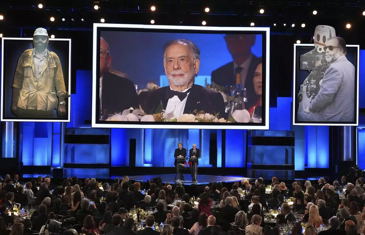 Filmmaker Francis Ford Coppola is displayed on a screen as actors Al Pacino, left, and Robert De Niro talk about his career during the 50th AFI Life Achievement Award tribute to Coppola on Saturday, April 26, 2025, at the Dolby Theatre in Los Angeles. (AP Photo/Chris Pizzello)