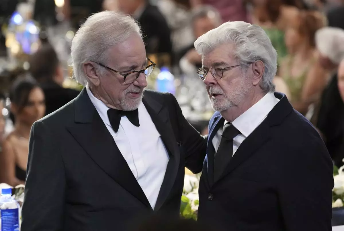 Filmmakers Steven Spielberg, left, and George Lucas mingle during the 50th AFI Life Achievement Award tribute to Francis Ford Coppola on Saturday, April 26, 2025, at the Dolby Theatre in Los Angeles. (AP Photo/Chris Pizzello)