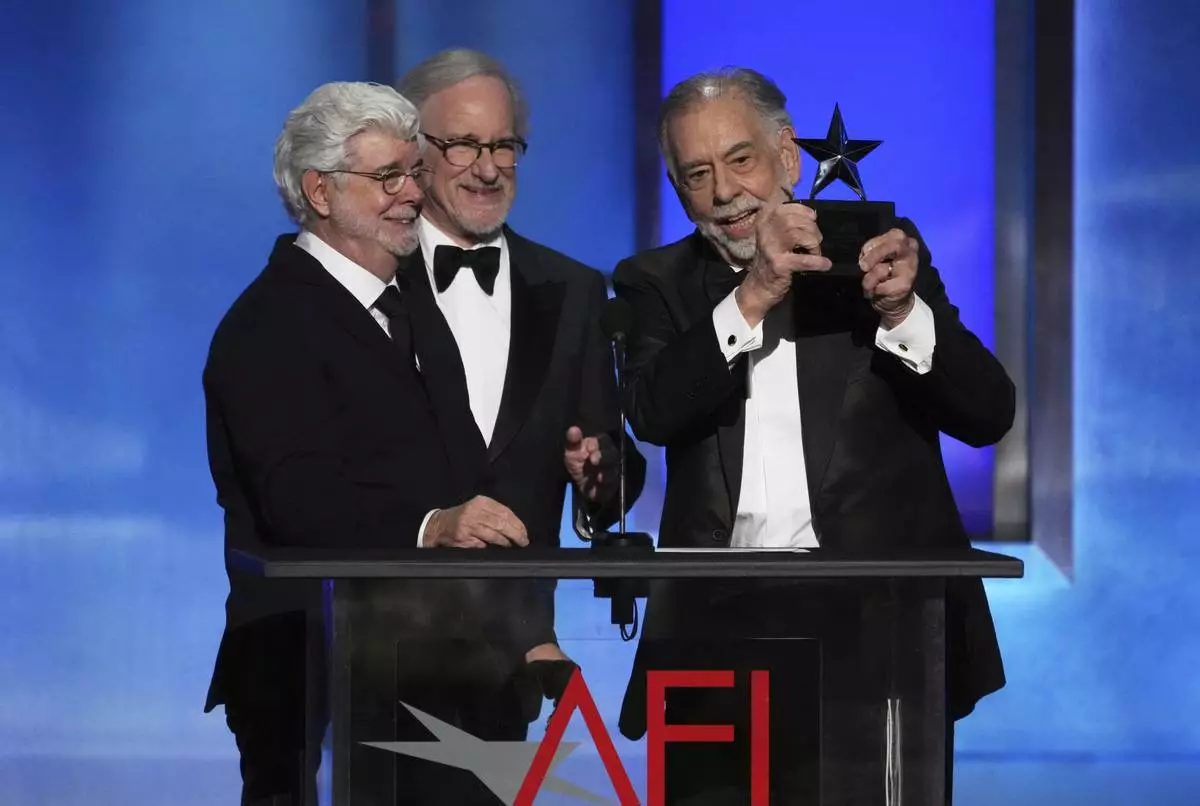 Filmmaker Francis Ford Coppola, right, accepts the 50th AFI Life Achievement Award from presenters George Lucas, left, and Steven Spielberg on Saturday, April 26, 2025, at the Dolby Theatre in Los Angeles. (AP Photo/Chris Pizzello)