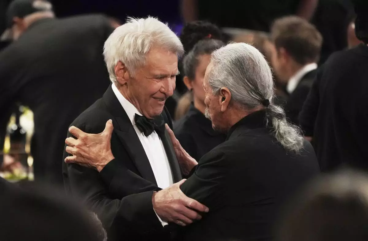 Harrison Ford, left, and Edward James Olmos greet each other during the 50th AFI Life Achievement Award tribute to Francis Ford Coppola on Saturday, April 26, 2025, at the Dolby Theatre in Los Angeles. (AP Photo/Chris Pizzello)