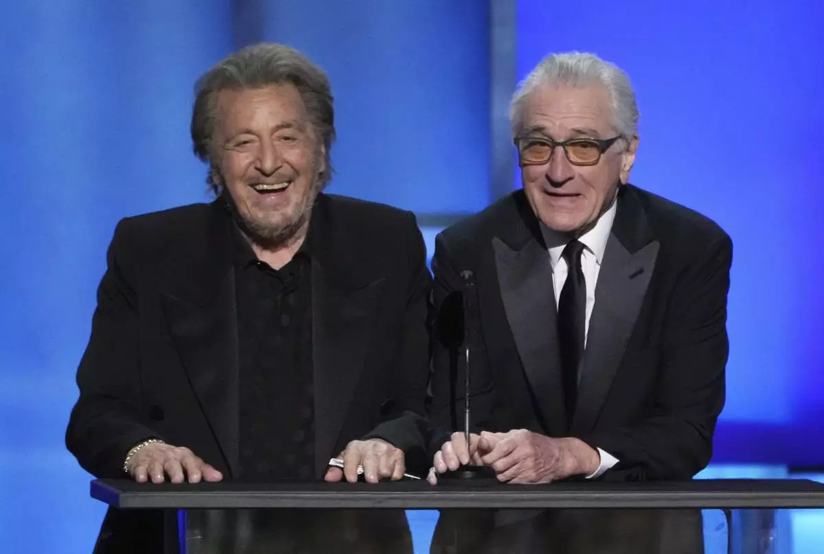 Actors Al Pacino, left, and Robert De Niro share a laugh onstage during the 50th AFI Life Achievement Award tribute to Francis Ford Coppola on Saturday, April 26, 2025, at the Dolby Theatre in Los Angeles. (AP Photo/Chris Pizzello)