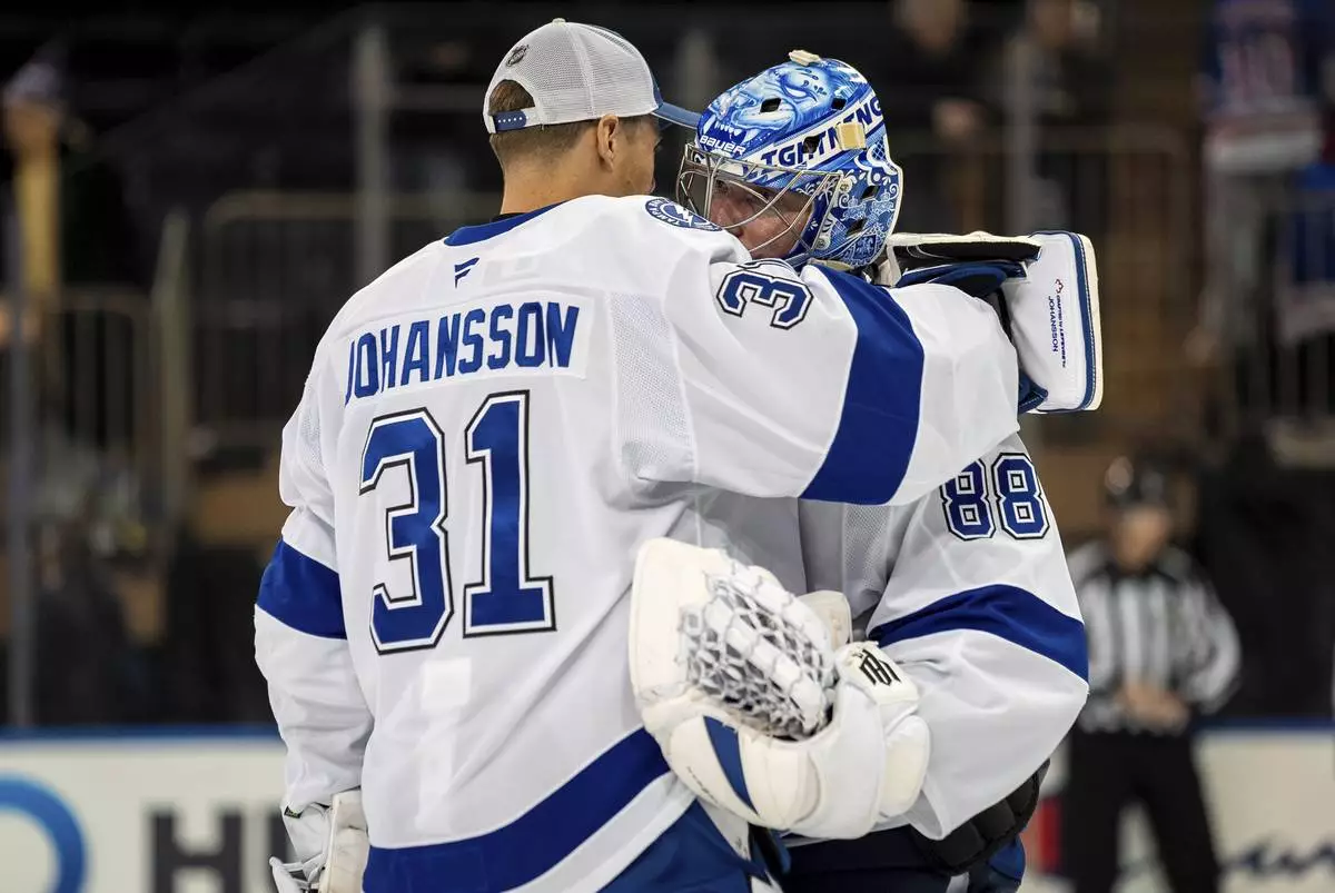 Tampa Bay Lightning goaltender Jonas Johansson (31) congratulates goaltender Andrei Vasilevskiy (88) after an NHL hockey game against the New York Rangers, Monday, April 7, 2025, in New York. (AP Photo/Angelina Katsanis)