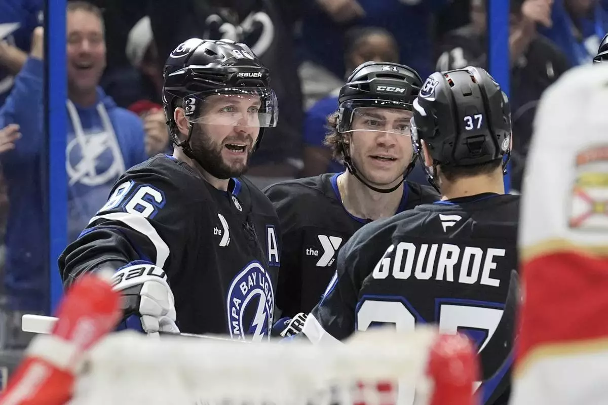 Tampa Bay Lightning right wing Nikita Kucherov (86) celebrates his goal against the Florida Panthers with center Brayden Point (21) and center Yanni Gourde (37) during the second period of an NHL hockey game Tuesday, April 15, 2025, in Tampa, Fla. (AP Photo/Chris O'Meara)