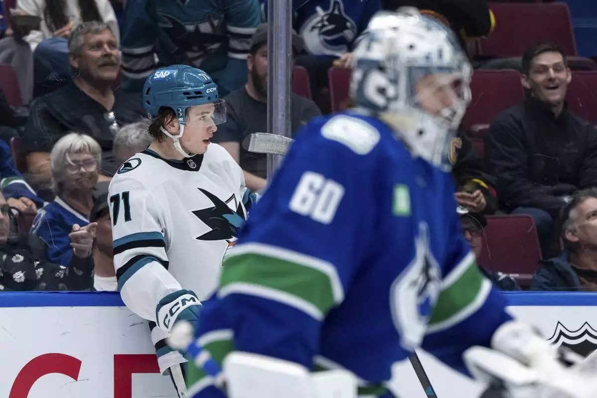 San Jose Sharks' Macklin Celebrini (71) celebrates after his goal as Vancouver Canucks goaltender Nikita Tolopilo (60) skates to the bench during the second period of an NHL hockey game in Vancouver, British Columbia, Monday, April 14, 2025. (Ethan Cairns/The Canadian Press via AP)