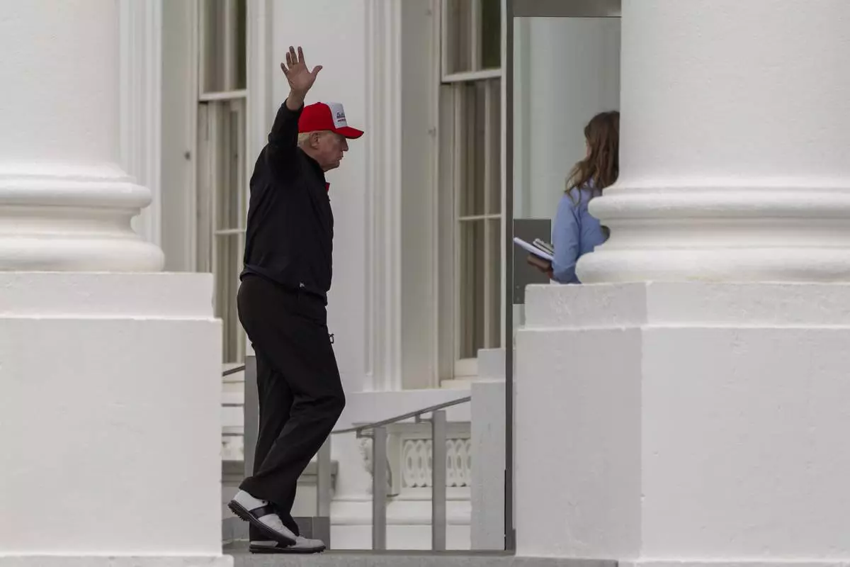 President Donald Trump waves as he returns to the White House, Sunday, April 20, 2025, in Washington. (AP Photo/Alex Brandon)