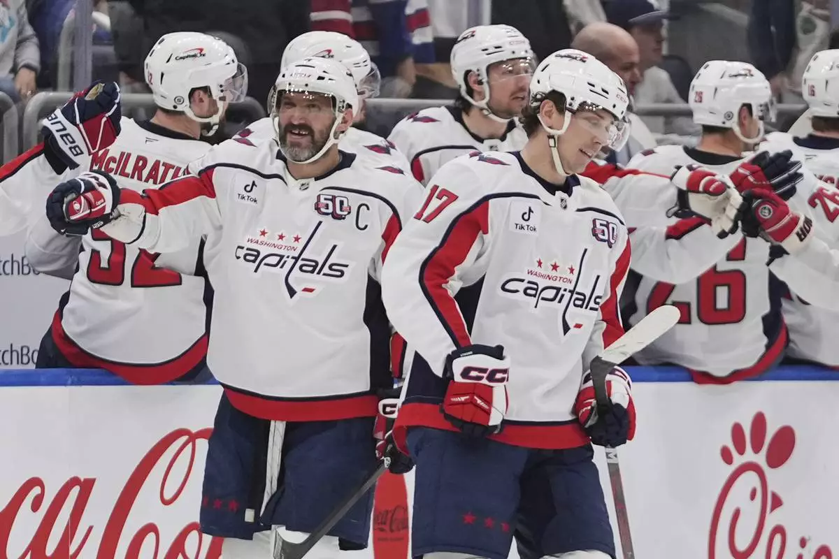 Washington Capitals' Dylan Strome, right, and Alex Ovechkin, left, celebrate with teammates after Strome scored a goal during the second period of an NHL hockey game against the New York Islanders Tuesday, April 15, 2025, in Elmont, N.Y. (AP Photo/Frank Franklin II)