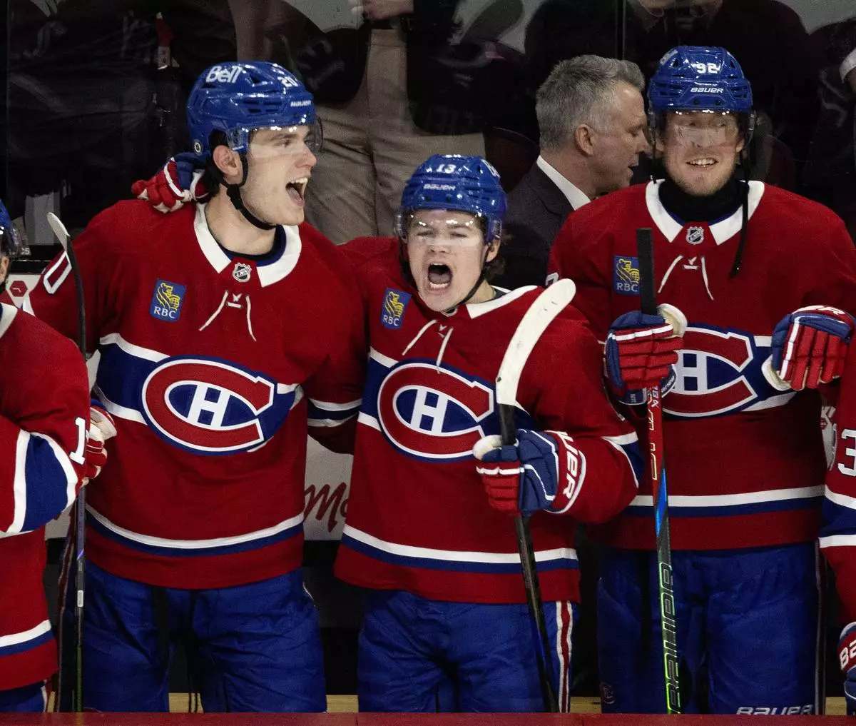 Montreal Canadiens' Juraj Slafkovsky (20), Cole Caufield (13) and Patrik Laine (92) celebrate after defeating the Carolina Hurricanes in NHL hockey action in Montreal on Wednesday, April 16, 2025. (Allen McInnis/The Canadian Press via AP)