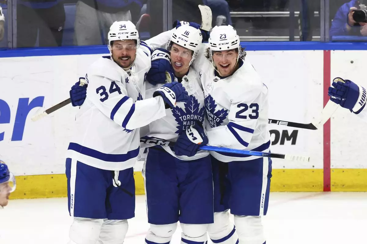 Toronto Maple Leafs right wing Mitch Marner (16) celebrates his goal with center Auston Matthews (34) and left wing Matthew Knies (23) during the third period of an NHL hockey game against the Buffalo Sabres, Tuesday, April 15, 2025, in Buffalo, N.Y. (AP Photo/Jeffrey T. Barnes)