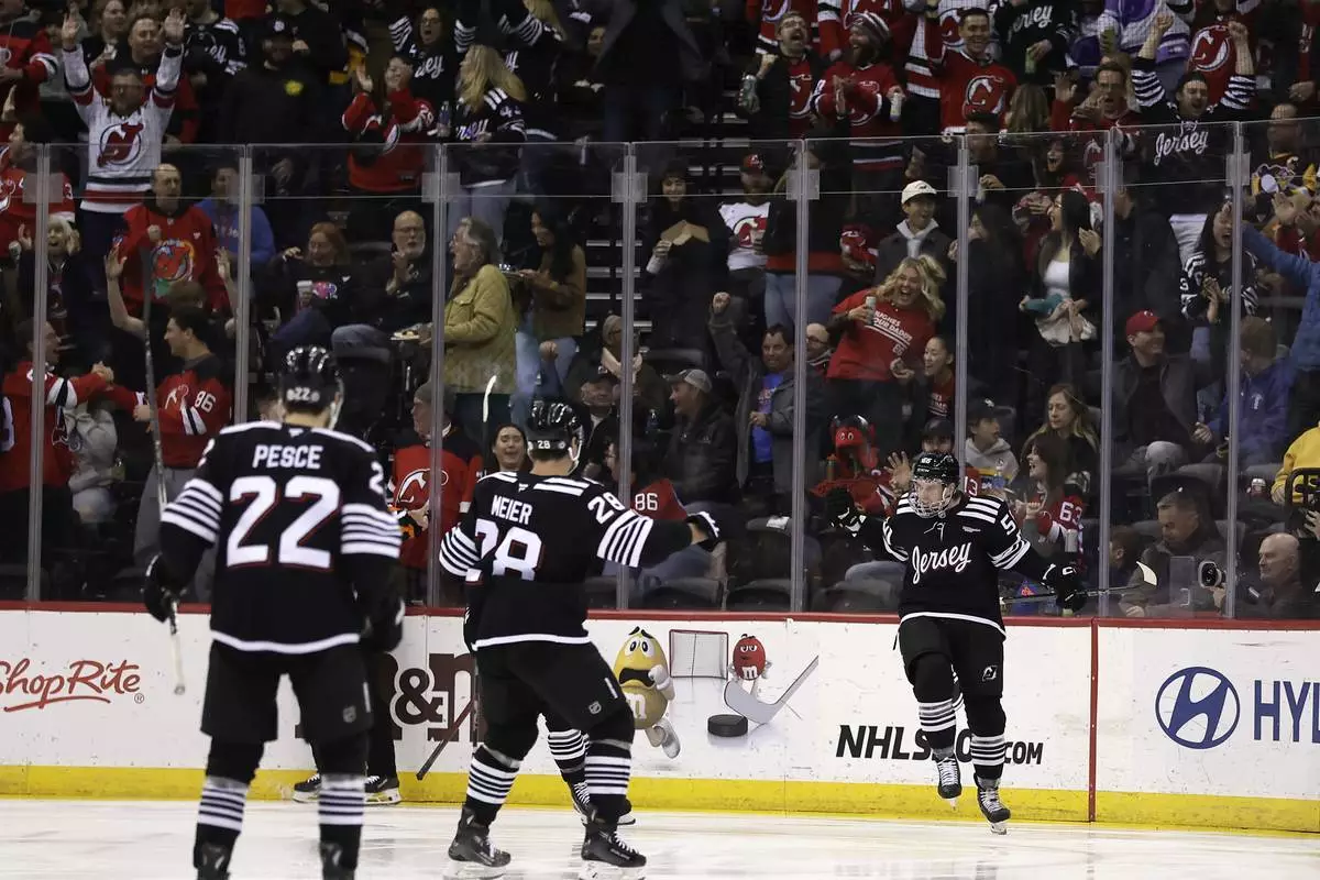 New Jersey Devils left wing Erik Haula, right, celebrates toward teammates after scoring a goal in the first period of an NHL hockey game against the Pittsburgh Penguins, Friday, April 11, 2025, in Newark, N.J. (AP Photo/Adam Hunger)