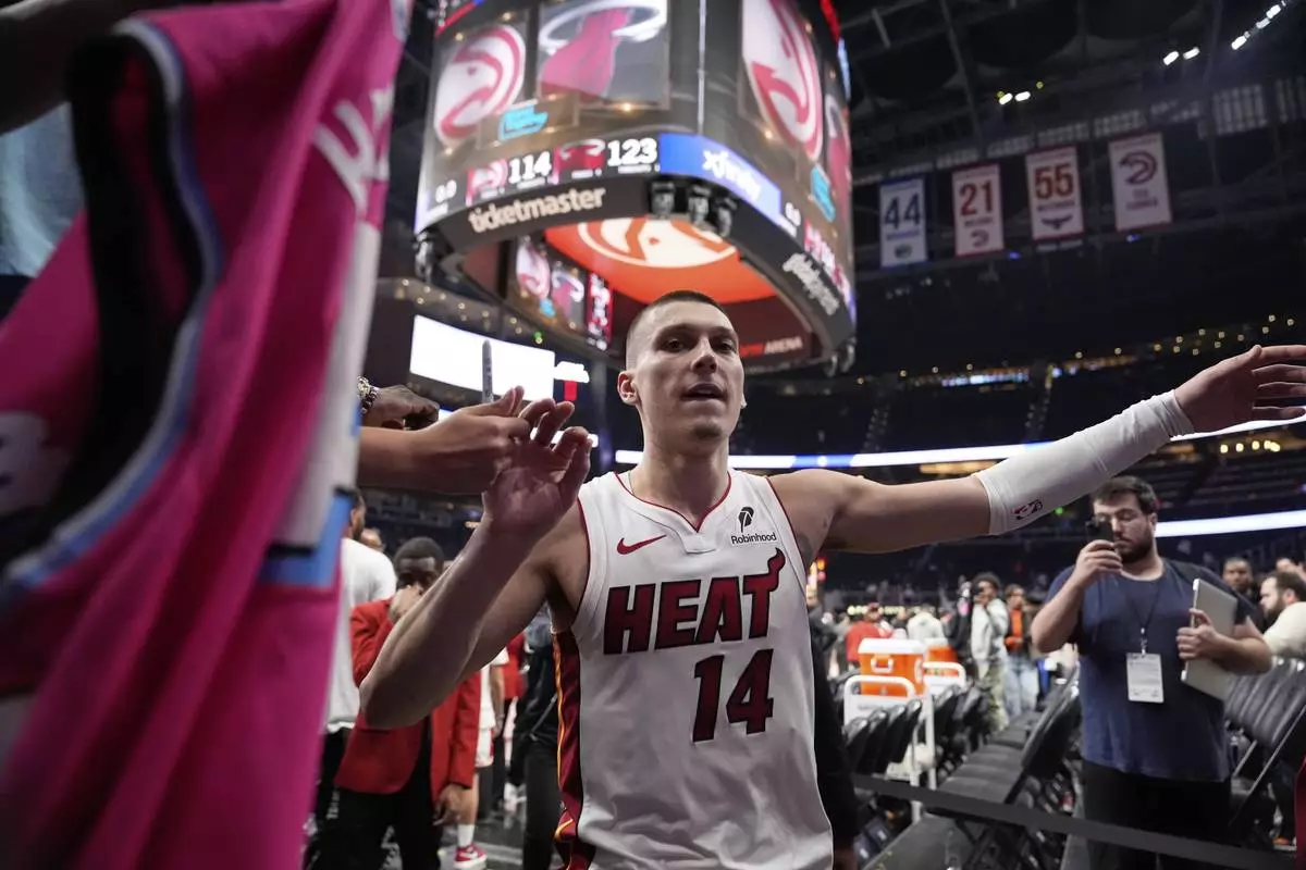 Miami Heat guard Tyler Herro (14) leaves the court after a win against the Atlanta Hawks after an NBA play-in tournament basketball, Friday, April 18, 2025, in Atlanta. (AP Photo/Brynn Anderson)
