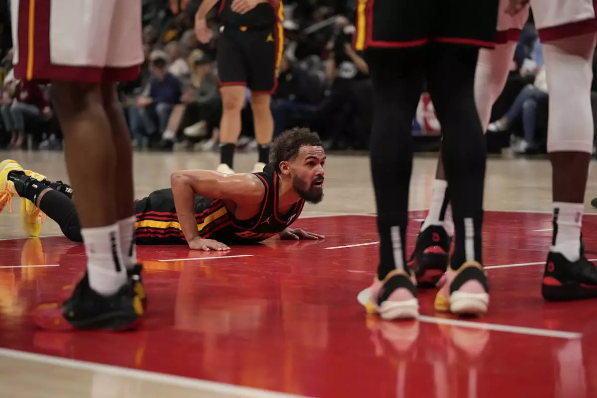 Atlanta Hawks guard Trae Young (11) falls and gets a foul in the first half of an NBA play-in tournament basketball game against the Miami Heat, Friday, April 18, 2025, in Atlanta. (AP Photo/Brynn Anderson)